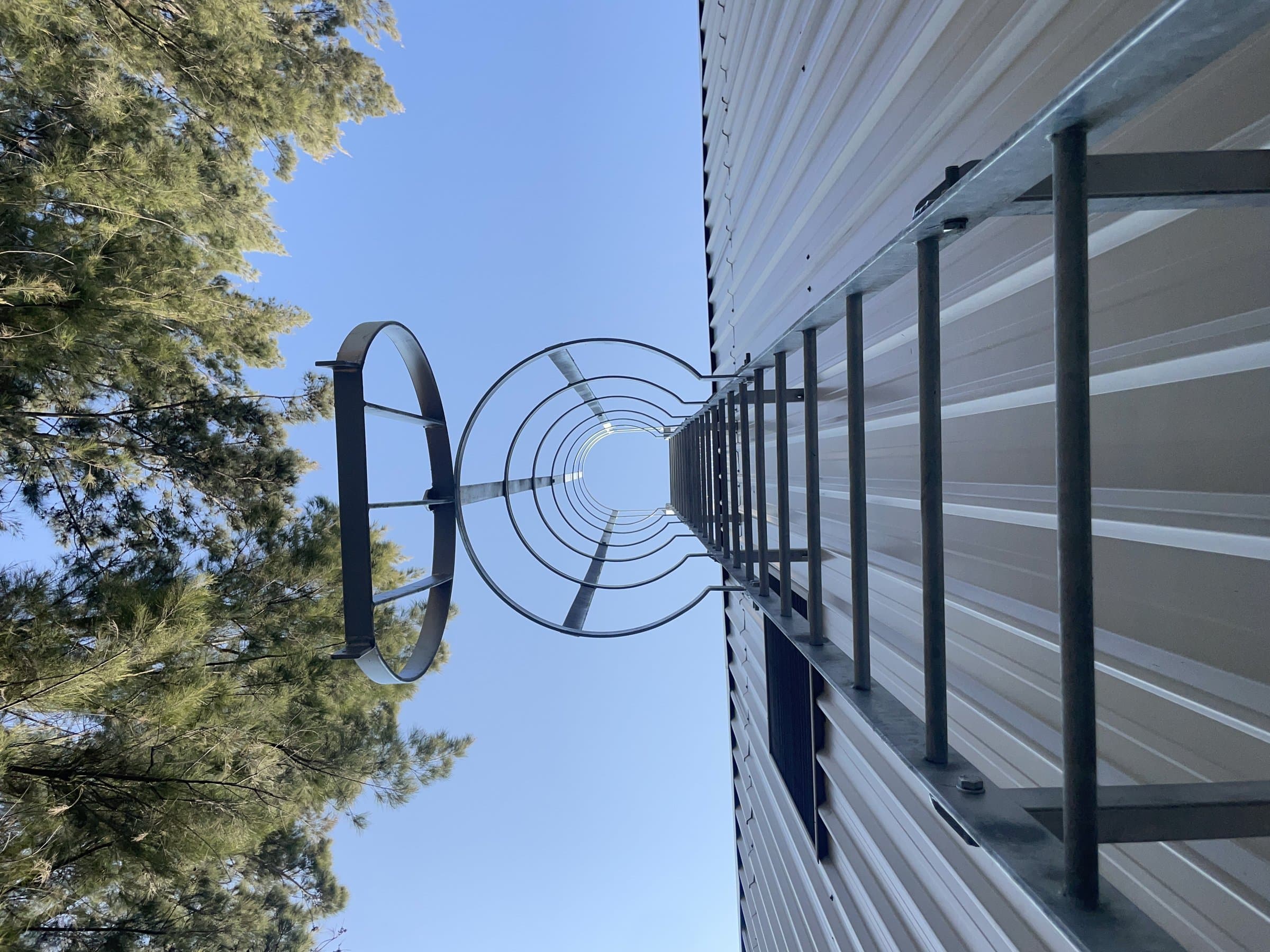 Installed rooftop fall protection cage and access ladder